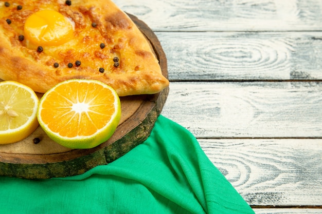 Front close view delicious egg bread baked with cheese on a rustic grey desk