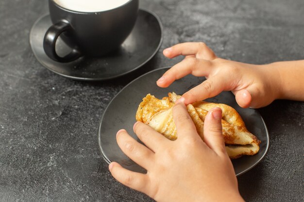 暗い机の上に牛乳とおいしいパンケーキのフロントビューを閉じる