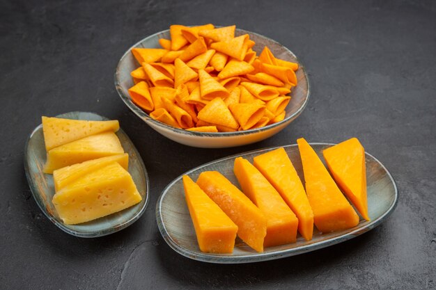 Front close view of delicious snacks for parties on the left side on a dark background