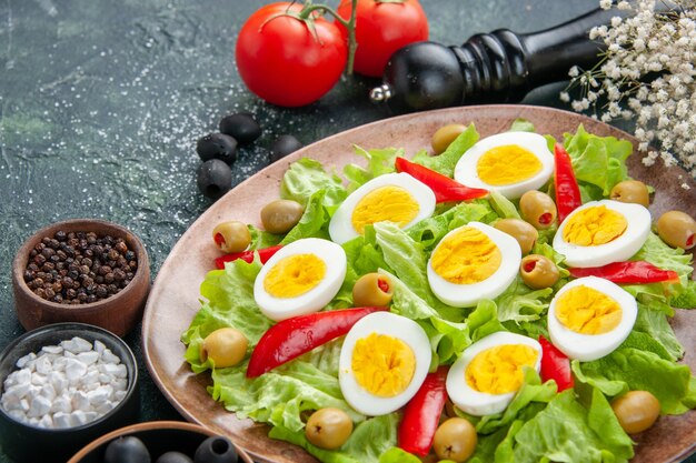 front close view egg salad with green salad olives and tomatoes on dark background