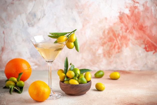 カラフルな表面にガラスのゴブレットに入った新鮮な柑橘系の果物とワインを正面から見た図