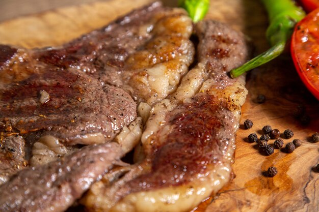 Front close view fried cooked meat with fried vegetables on the wooden surface