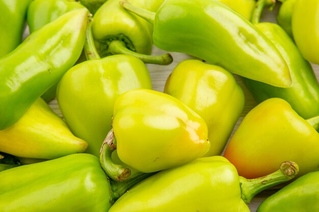 Front close view green bell-peppers on white color ripe meal plant photo vegetable pepper salad