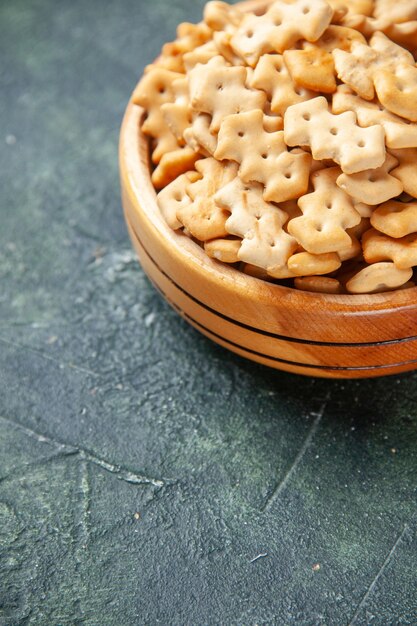 Front close view little crackers inside plate on a dark background crisp snack salt bread rusk food cips color