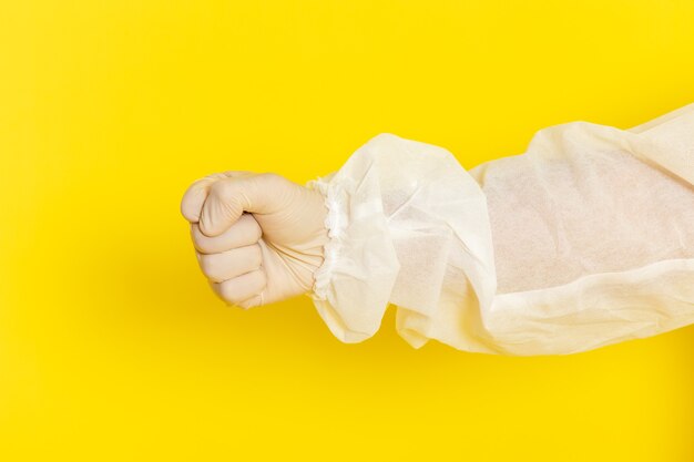 Front close view of male scientific worker in special protective suit on yellow wall