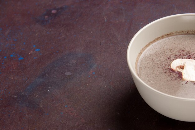 Front close view mushroom soup inside plate on the dark space