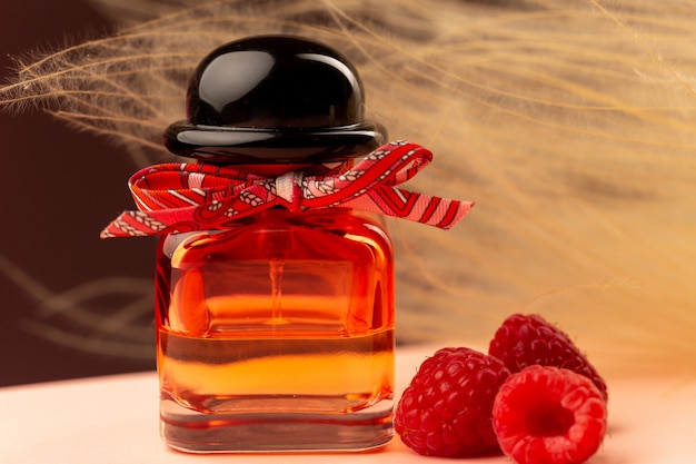 Free photo front close view raspberry smelling perfume inside flask on the purple surface
