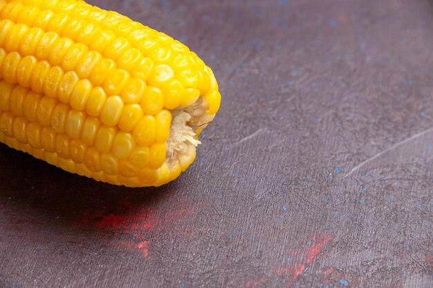 Front close view raw yellow corn on dark surface corn color plant popcorn