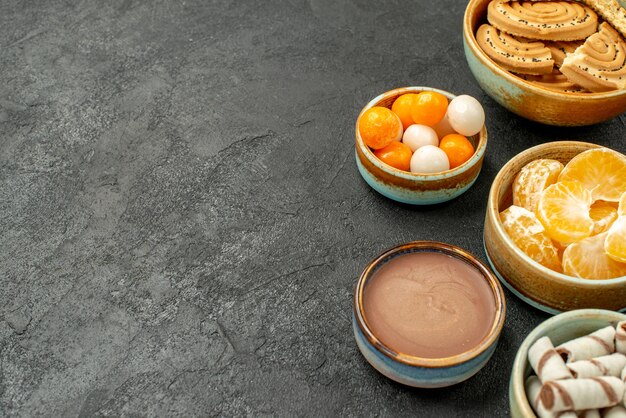 Вид спереди крупным планом сладкое печенье с конфетами на темном столе, печенье, печенье, сладкое