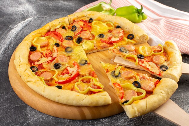 赤いトマト、ブラックオリーブ、ピーマン、ソーセージ、灰色の表面に正面の近くのおいしいチーズのピザ