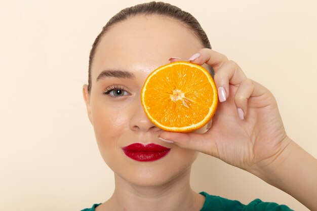 Front close view young attractive female in dark green shirt holding half orange