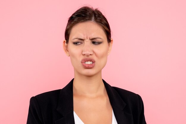 Front close view young female in dark jacket displeased on pink background