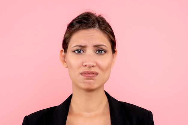 Front close view young female in dark jacket on pink background