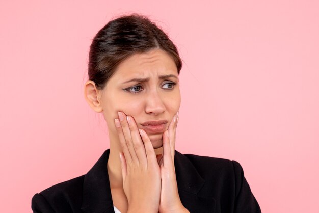 Front close view young female in dark jacket with sad face on pink background