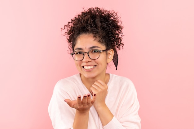 Front close view of young female smiling widely on pink