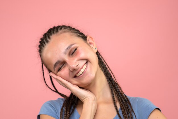 Front close view of young girl happily smiling on pink