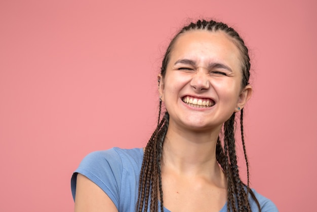 Front close view of young girl laughing on pink