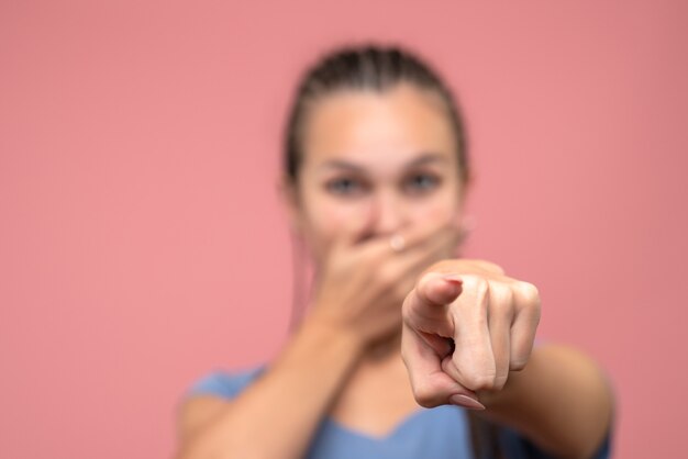 Front close view of young girl pointing on pink