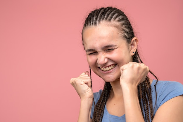 Front close view of young girl rejoicing on pink