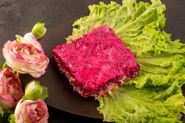 A front closed up view beet salad slice of mayonnaise salad along with green inside brown plate