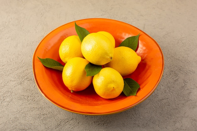 フロントクローズアップビュー黄色フレッシュレモン熟したまろやかなジューシーなグレーのオレンジプレート内