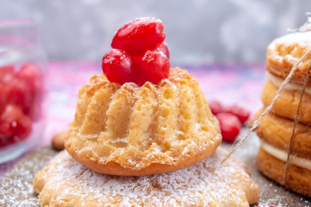 Foto gratuita vista ravvicinata anteriore piccola deliziosa torta con biscotti sandwich sulla scrivania luminosa