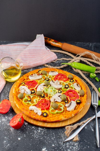 Front distant view tasty pizza with red tomatoes, green olives and mushrooms with fresh tomatoes all over the grey desk