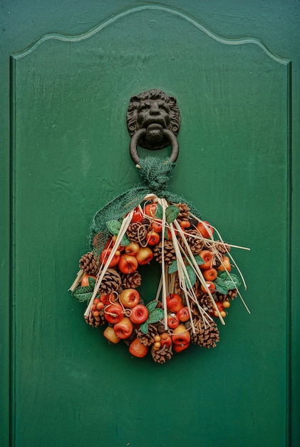 Free photo front door artificial garland with pine cones and fruits