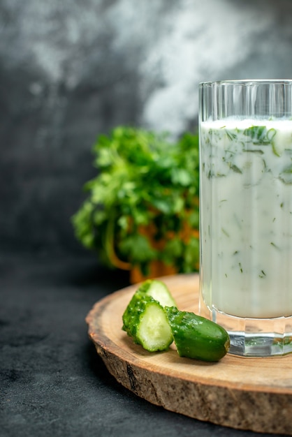 Free photo front half view atlama in glass chopped cucumber on wood board on grey isolated table