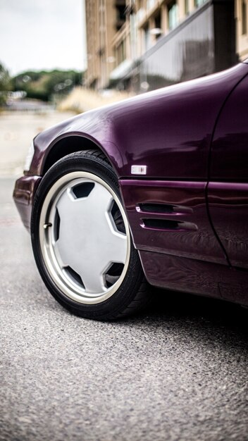 Front left wheel of a bordeaux sedan car.