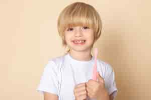 Free photo front portrait view, smiling boy little cute adorable in white t-shirt on pink wall