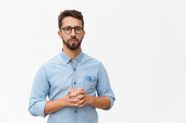 Front of serious confident man with clasped hands