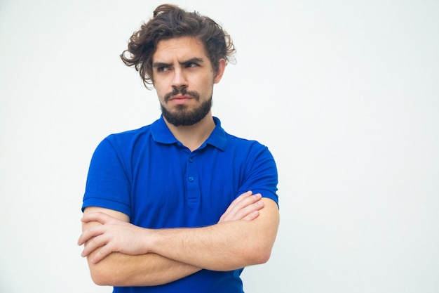 Front of serious frowning guy with crossed arms looking away