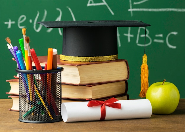 Front view of academic cap with books and pencils