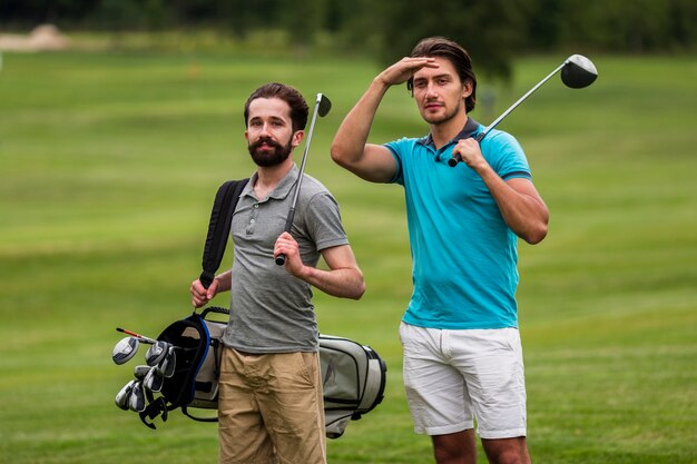 Front view adult friends playing golf