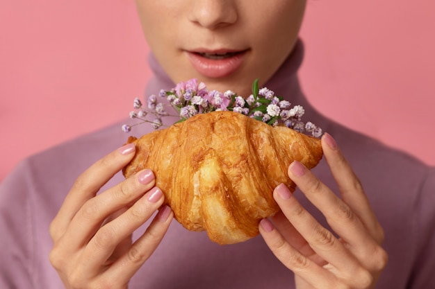 Front view adult holding croissant