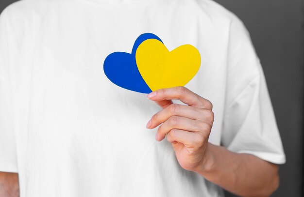 Вид спереди взрослый держит желтые и синие сердца