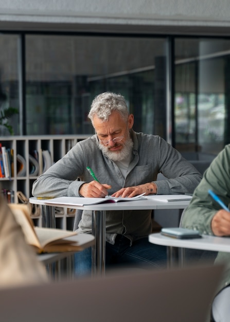 Foto gratuita adulti vista frontale che studiano insieme