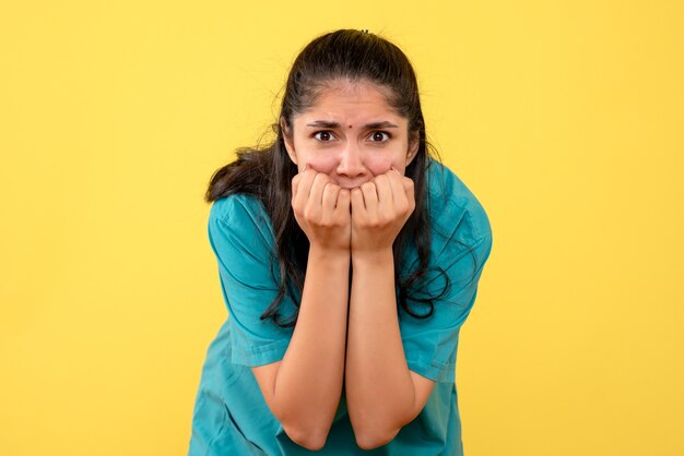 Front view agitated female doctor in uniform standing on yellow isolated background