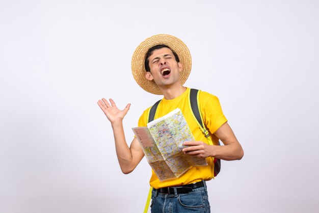 正面図黄色のTシャツと地図を保持している麦わら帽子で興奮した若い男