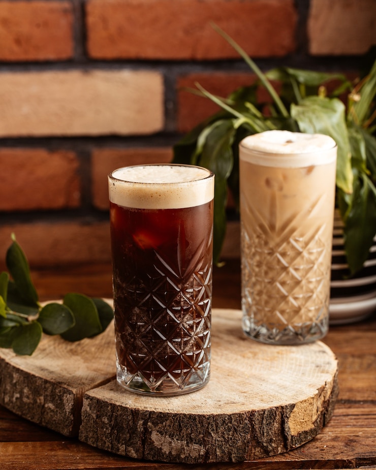 Free Photo a front view alcohol drinks inside glasses on the brown wooden desk