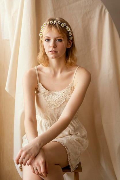 Free photo front view of alluring woman posing while wearing a spring flowers crown