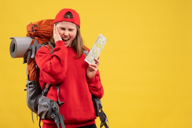 Front view angry female backpacker holding travel map holding her ear
