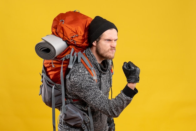 Front view of angry male hitchhiker with leather gloves and backpack being to ready fight