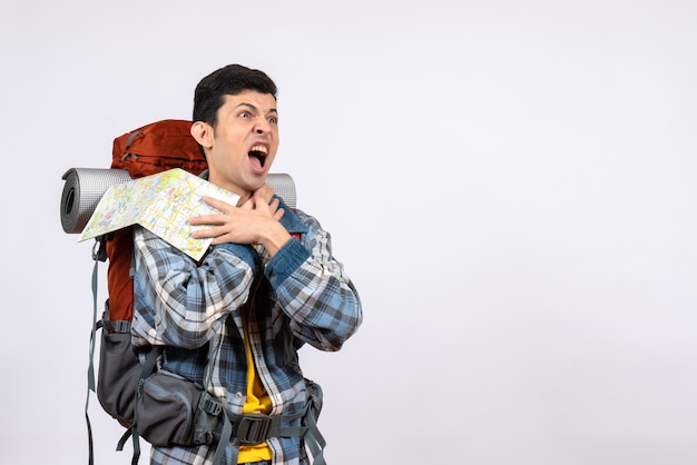 Бесплатное фото Вид спереди сердитый молодой путешественник с рюкзаком, держащий карту