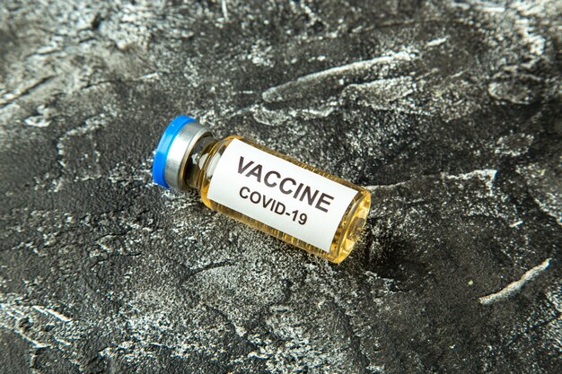 Front view antivirus vaccine in little flask on gray background health science lab pandemic virus covid- isolation hospital