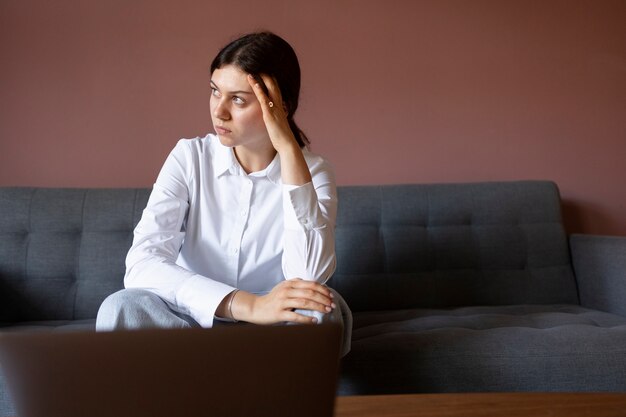 Front view anxious woman sitting on couch