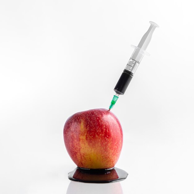 Front view apple and syringe with chemicals