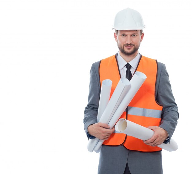 Front view of architect wearing in white safety hat and orange vest holding many paper drawing plans.