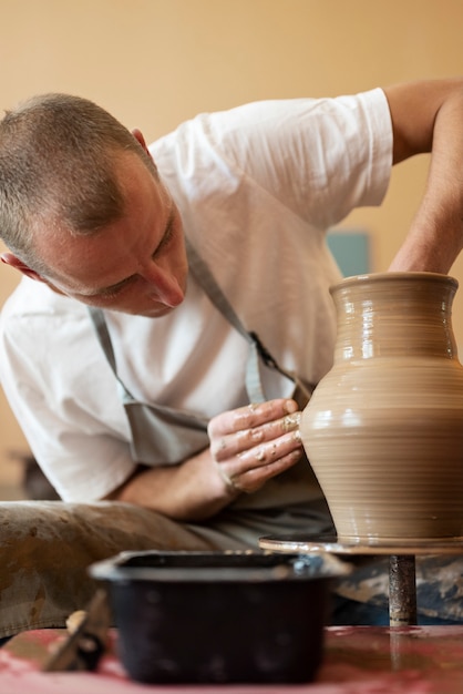 Foto gratuita artigiano di vista frontale che fa ceramica